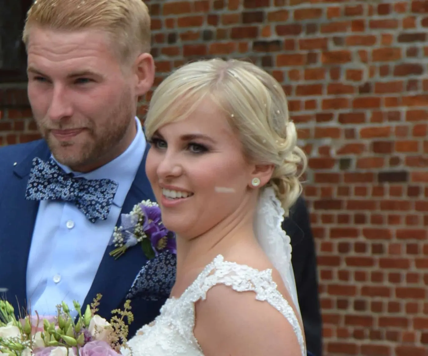 Brud med opsat hår og makeup sammen med brudgommen